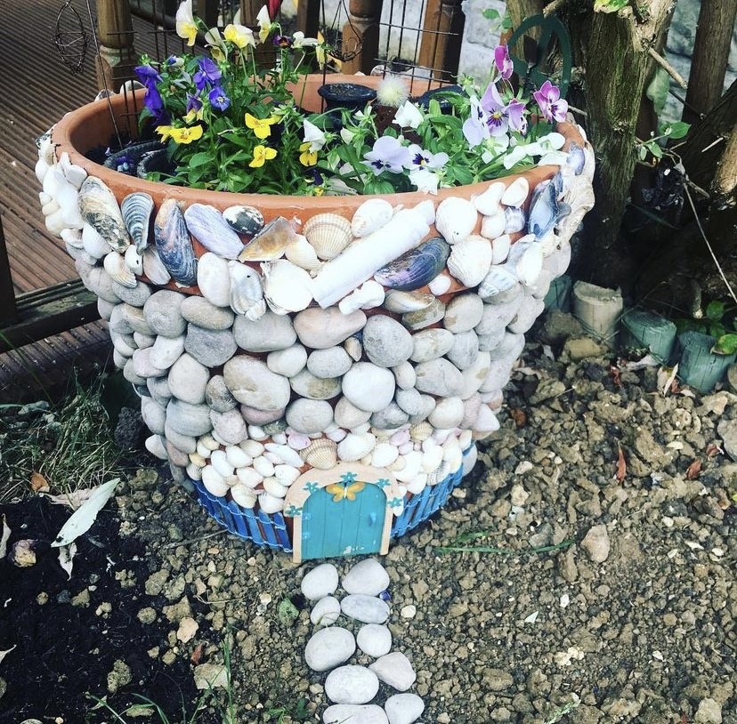 Flower pot decorated with shells and pebbles