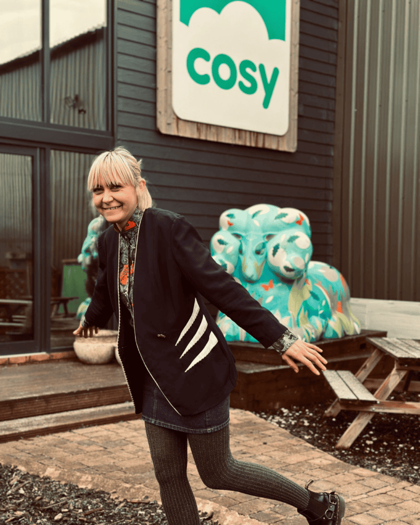 woman standing in front of a building with a Cosy Direct Logo